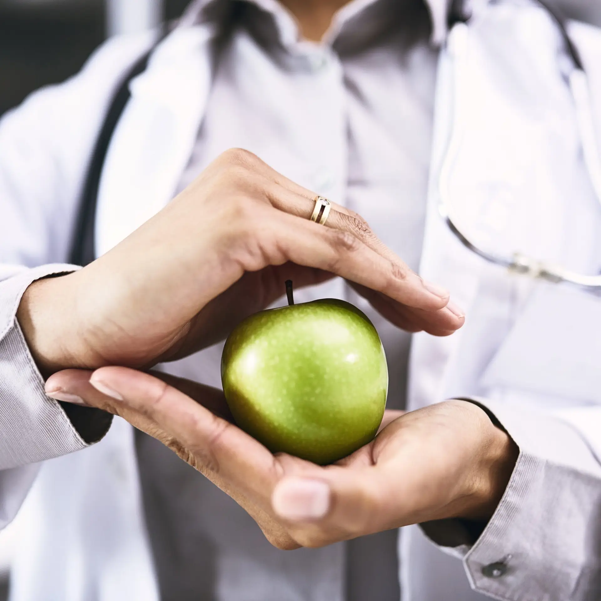 Closeup shot of an unidentifiable doctor holding an apple in her hands - The Bespoke Clinic | Jesmond, Newcastle